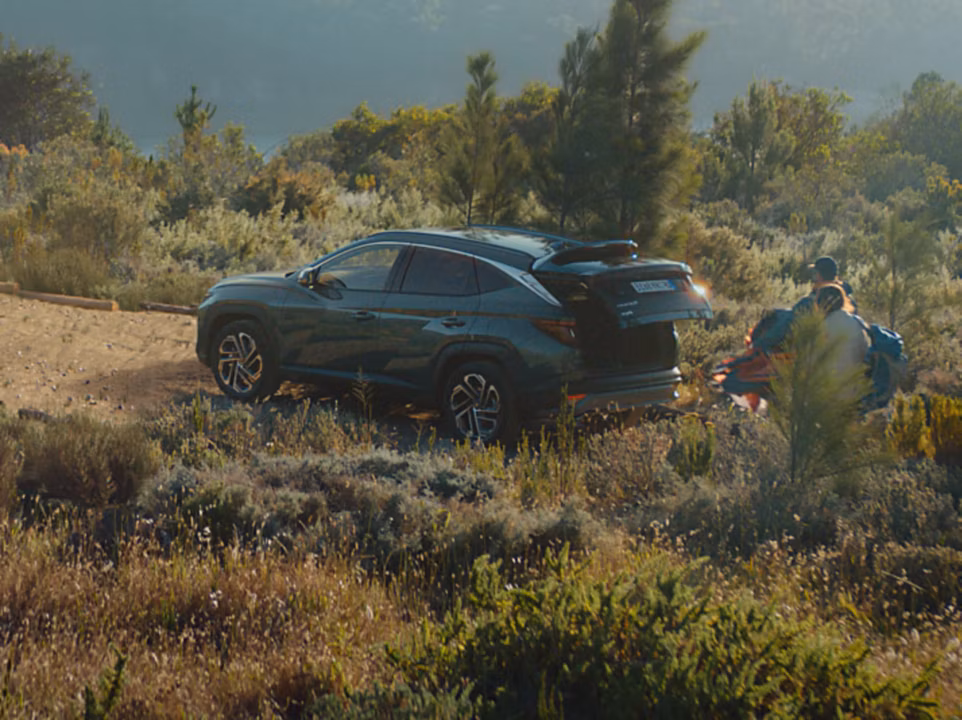 The Hyundai TUCSON Plug-in Hybrid parked on a gravel road in the forest. 